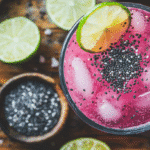 Overhead shot of seeded pink salt drink with lime and sesame on wooden table
